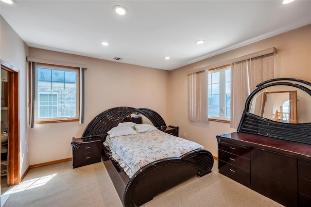 bedroom featuring baseboards, multiple windows, visible vents, and light carpet