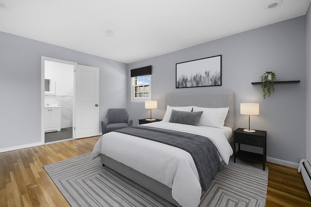 125 Lakewood Dr, Congers, NY 10920 - bedroom featuring wood finished floors, a baseboard radiator, and connected bathroom