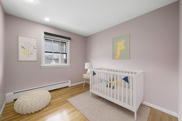 125 Lakewood Dr, Congers, NY 10920 - bedroom with a baseboard radiator, wood finished floors, recessed lighting, and a crib