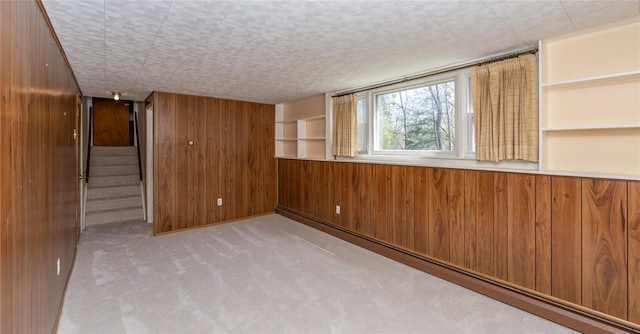 37 Lincoln Dr, Poughkeepsie, NY 12601 - carpeted spare room with wooden walls, stairway, built in shelves, and baseboard heating