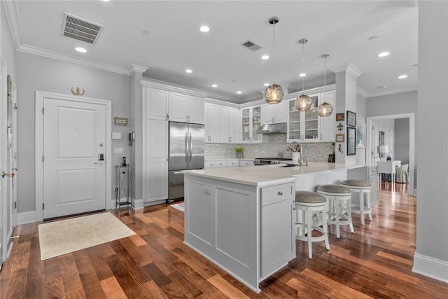 kitchen featuring a peninsula, visible vents, stainless steel built in fridge, and glass insert cabinets