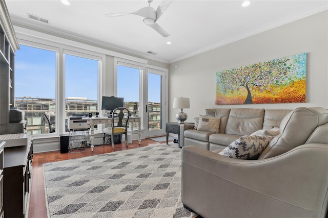 living area featuring crown molding, ceiling fan, wood finished floors, and visible vents