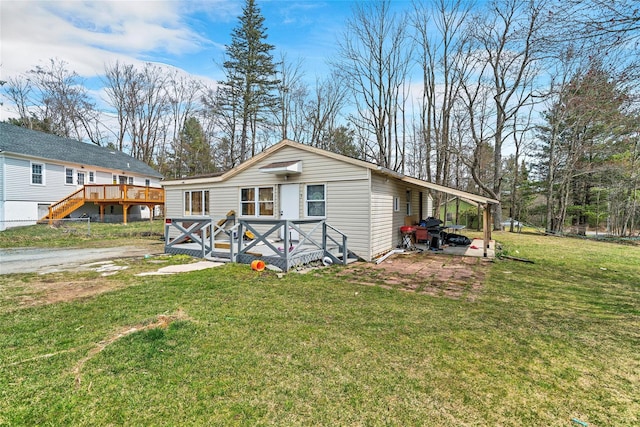 manufactured / mobile home featuring a front yard and a deck