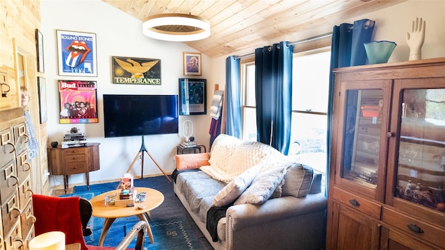 living area with baseboards, vaulted ceiling, and wooden ceiling