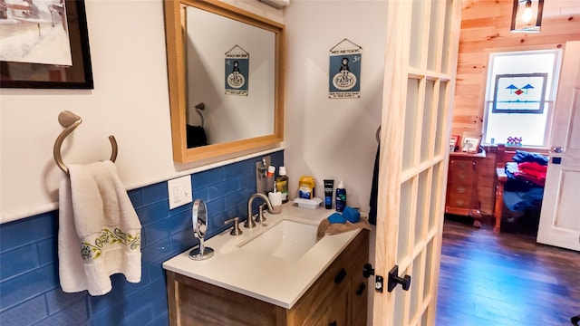 bathroom featuring wood finished floors, vanity, and decorative backsplash