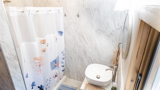 full bathroom with curtained shower and tile walls