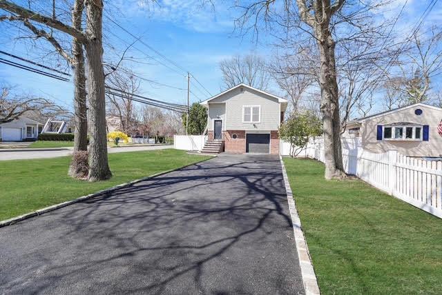 view of front of home featuring fence, a front lawn, driveway, and a garage