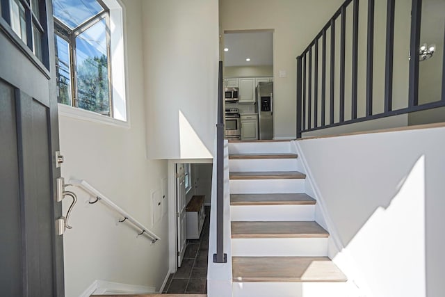 stairway with baseboards, tile patterned floors, and recessed lighting