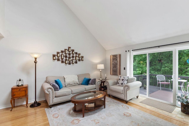 living area with high vaulted ceiling and wood finished floors