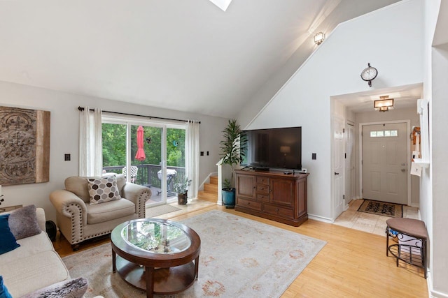 living room featuring high vaulted ceiling and wood finished floors