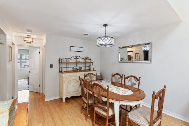 dining area featuring an inviting chandelier, baseboards, light wood-type flooring, and visible vents