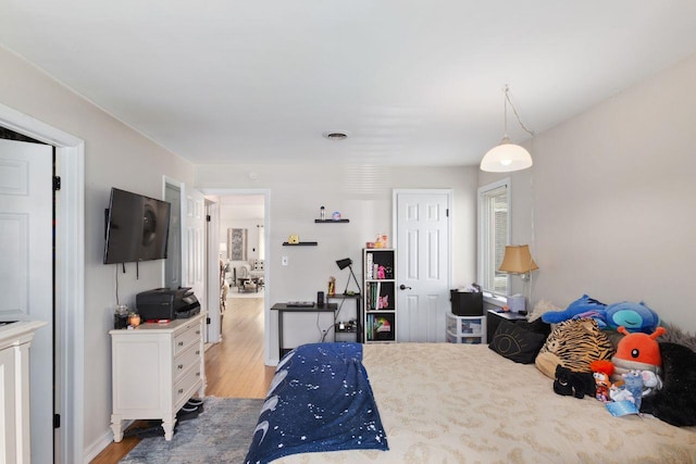 bedroom with light wood-type flooring and visible vents