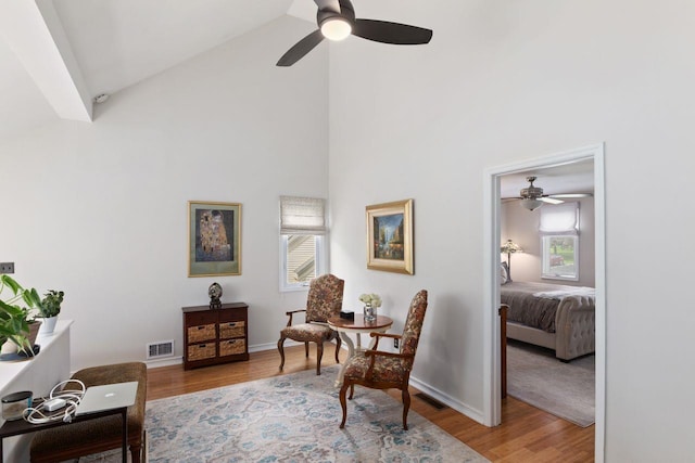 sitting room featuring ceiling fan, visible vents, a wealth of natural light, and high vaulted ceiling