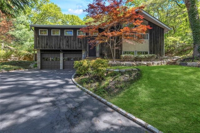 9 Salonga Woods Rd, Northport, NY 11768 - view of front of house featuring an attached garage, asphalt driveway, and a front lawn