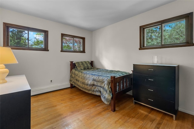 9 Salonga Woods Rd, Northport, NY 11768 - bedroom featuring a baseboard radiator, multiple windows, light wood-style floors, and baseboards