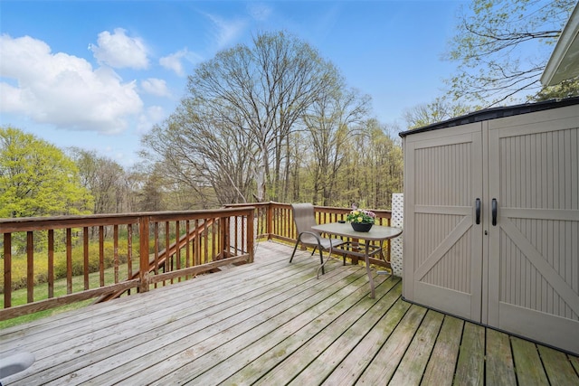 wooden terrace with a storage unit and an outbuilding