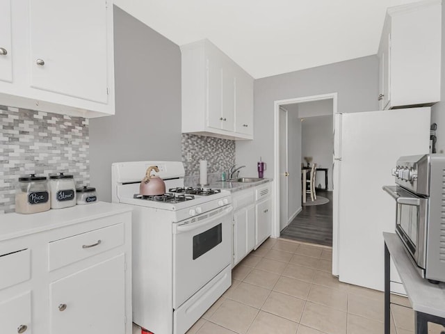 270 N Broadway Unit 6H, Yonkers, NY 10701 - kitchen featuring white gas range oven, a sink, tasteful backsplash, light countertops, and light tile patterned floors