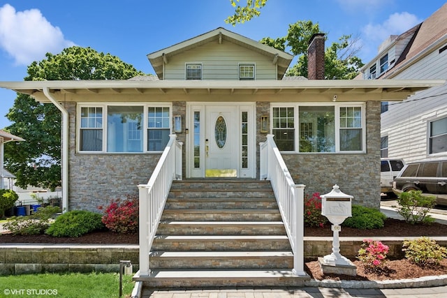 66 Vernon Ave, Mount Vernon, NY 10553 - view of front of house with stone siding, a chimney, and entry steps