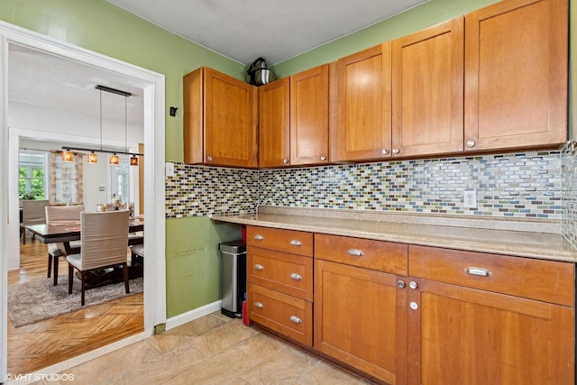 66 Vernon Ave, Mount Vernon, NY 10553 - kitchen featuring light countertops, brown cabinetry, and backsplash
