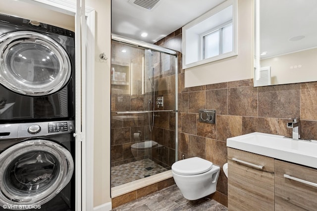 66 Vernon Ave, Mount Vernon, NY 10553 - full bath featuring stacked washer / dryer, a stall shower, toilet, vanity, and tile walls