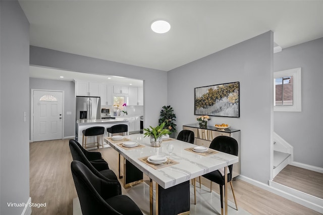 dining room with baseboards, light wood-type flooring, a wealth of natural light, and recessed lighting