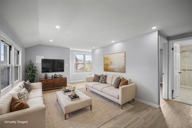 living area with baseboards, light wood-type flooring, vaulted ceiling, and recessed lighting