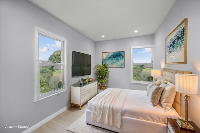 bedroom featuring baseboards, recessed lighting, multiple windows, and light wood finished floors