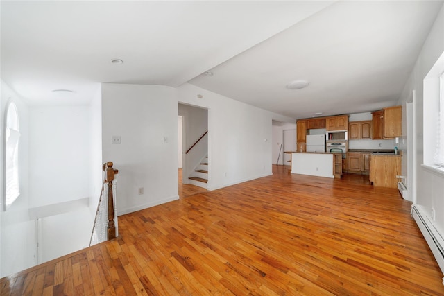 unfurnished living room with stairway, baseboards, a baseboard heating unit, and light wood-type flooring