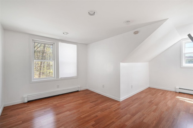 bonus room featuring baseboards, baseboard heating, and light wood-style flooring