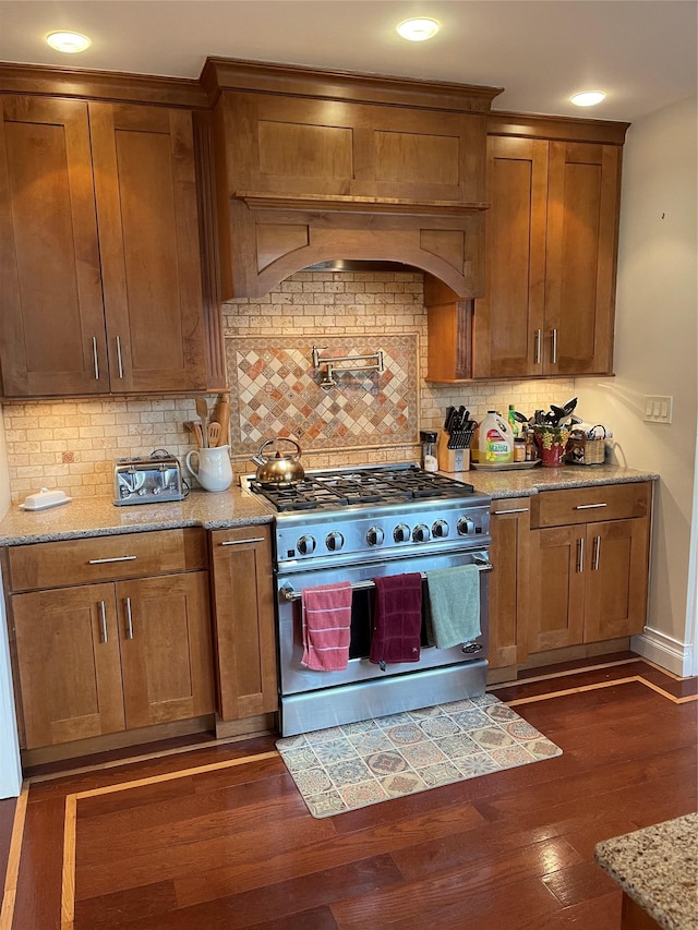 20815 38th Ave, Bayside, NY 11361 - kitchen featuring stainless steel stove, brown cabinets, decorative backsplash, dark wood finished floors, and baseboards
