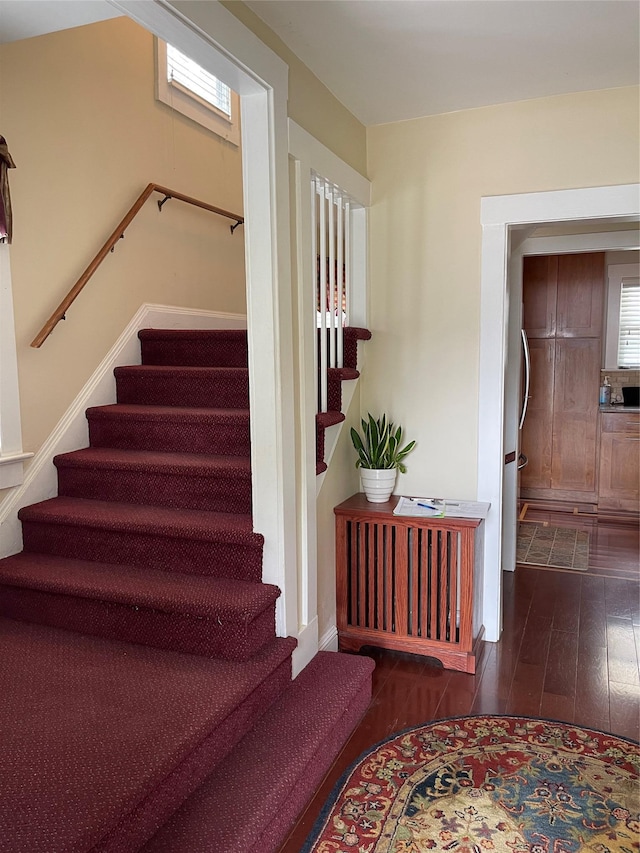 20815 38th Ave, Bayside, NY 11361 - stairway with wood finished floors, radiator, and baseboards