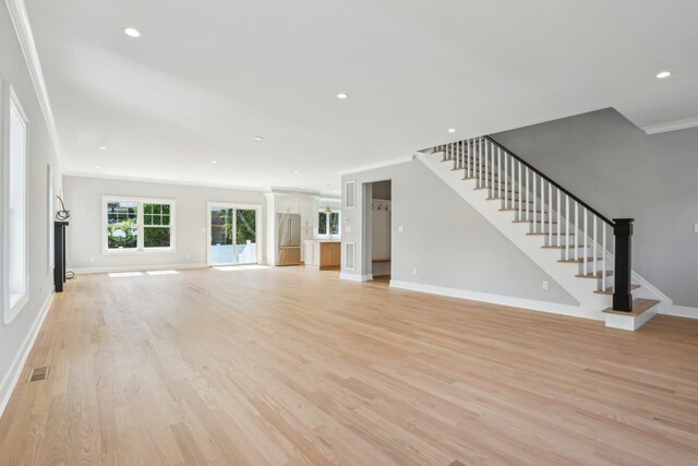 44 Harbor Hills Dr, Port Washington, NY 11050 - unfurnished living room with visible vents, crown molding, light wood finished floors, and stairs