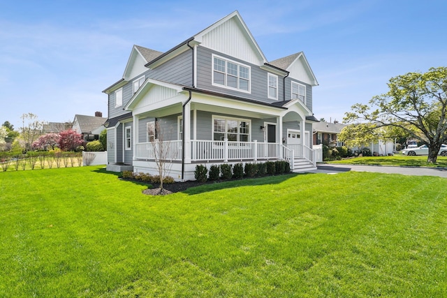 44 Harbor Hills Dr, Port Washington, NY 11050 - view of front of home with a front yard, board and batten siding, and covered porch