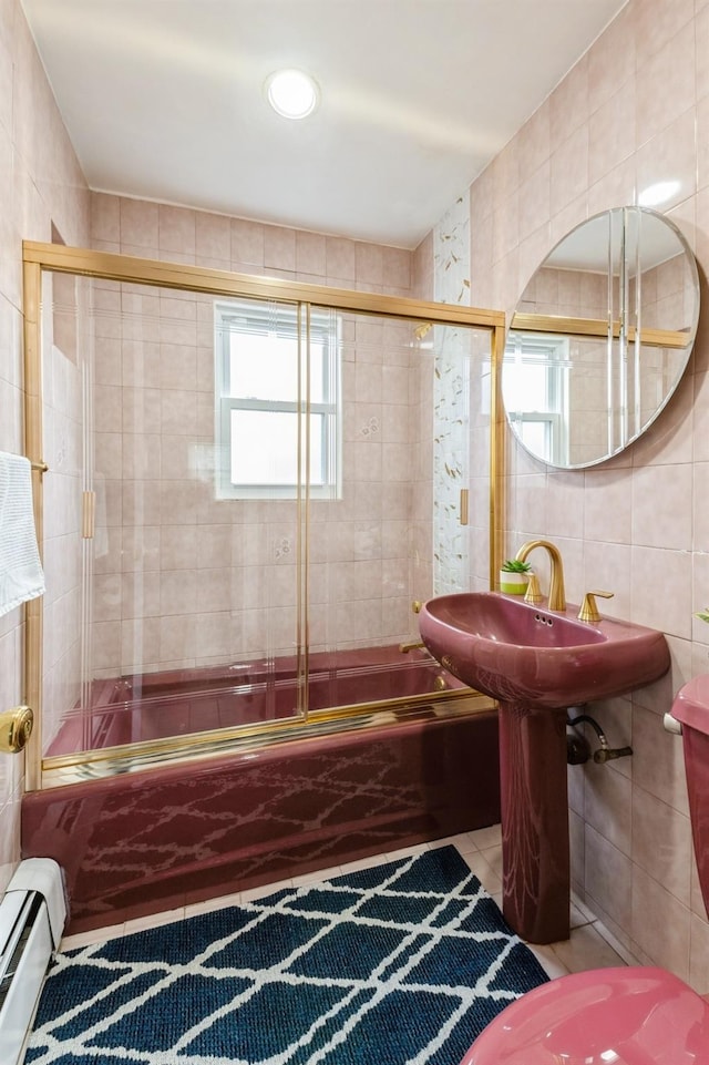 186 Stuart Rd, Valley Stream, NY 11581 - bathroom with a baseboard radiator, combined bath / shower with glass door, and tile walls