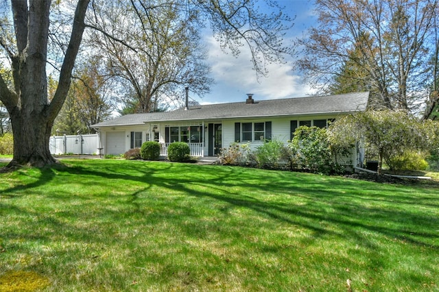 ranch-style house with a front lawn, an attached garage, and fence