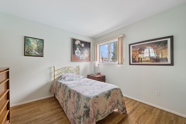 bedroom with baseboards and wood finished floors