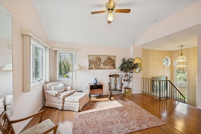 sitting room featuring a healthy amount of sunlight, an upstairs landing, wood finished floors, and lofted ceiling