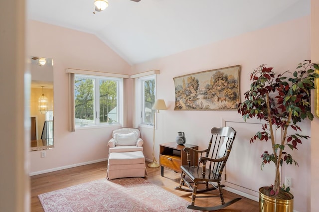 sitting room with a ceiling fan, baseboards, wood finished floors, and lofted ceiling