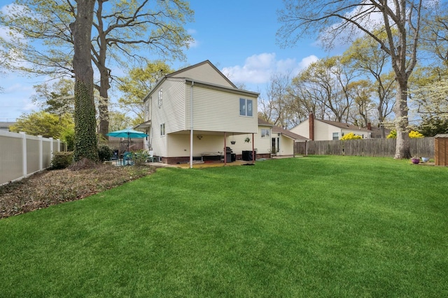 rear view of property with a lawn and a fenced backyard