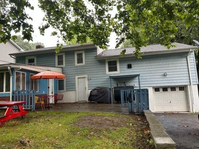 7 Ash St, New Windsor, NY 12553 - rear view of house with asphalt driveway, an attached garage, and a sunroom