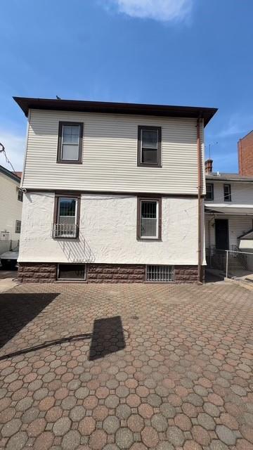 rear view of property featuring fence