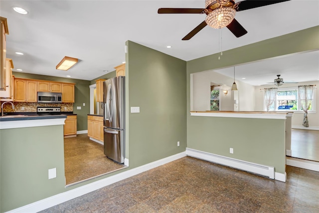 kitchen with baseboard heating, a ceiling fan, appliances with stainless steel finishes, and dark countertops