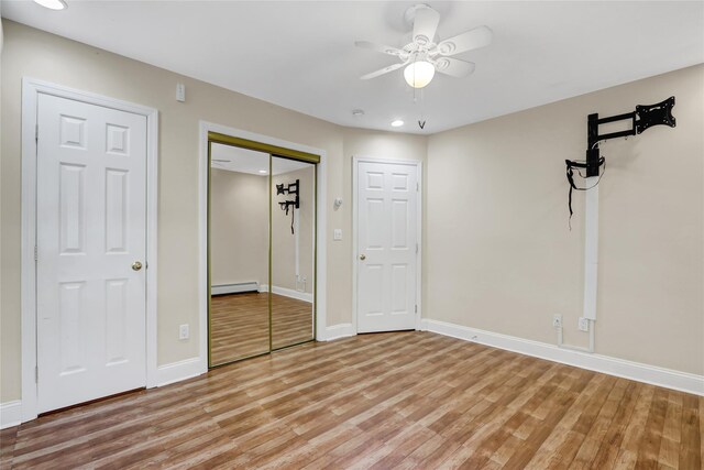 unfurnished bedroom featuring a baseboard radiator, baseboards, light wood-style floors, and recessed lighting