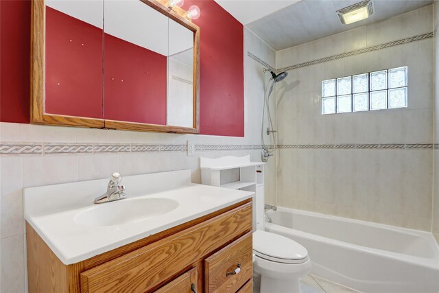 full bath featuring toilet, tile walls, shower / bathtub combination, visible vents, and vanity