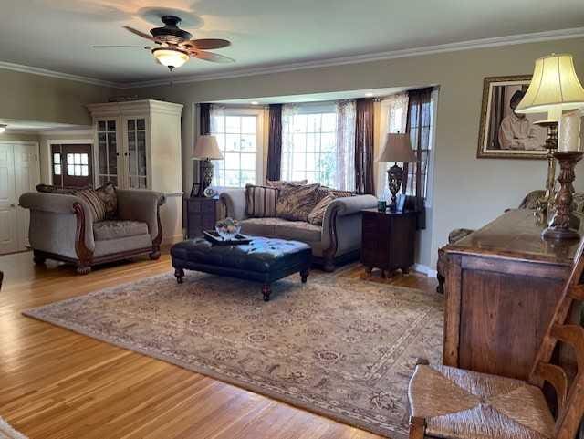 living room featuring ornamental molding, ceiling fan, and wood finished floors