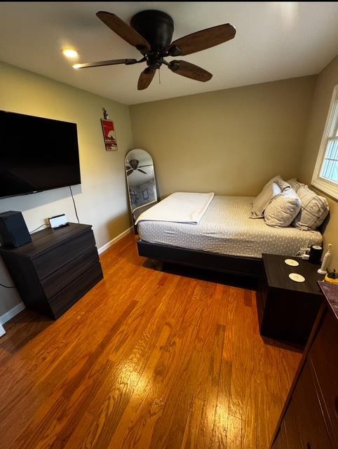 bedroom with baseboards, a ceiling fan, and wood finished floors