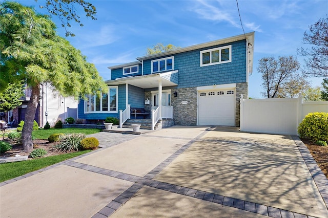 3359 Knight St, Oceanside, NY 11572 - traditional-style home featuring covered porch, a garage, fence, concrete driveway, and stone siding