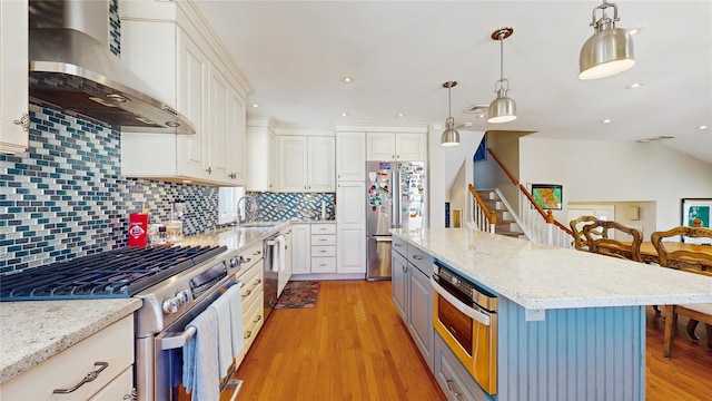 3359 Knight St, Oceanside, NY 11572 - kitchen featuring a breakfast bar, light wood-type flooring, wall chimney exhaust hood, white cabinetry, and appliances with stainless steel finishes