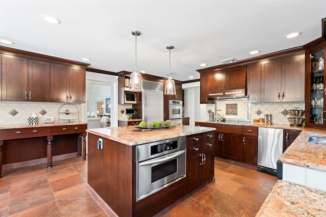 kitchen featuring a center island, recessed lighting, light stone countertops, and backsplash