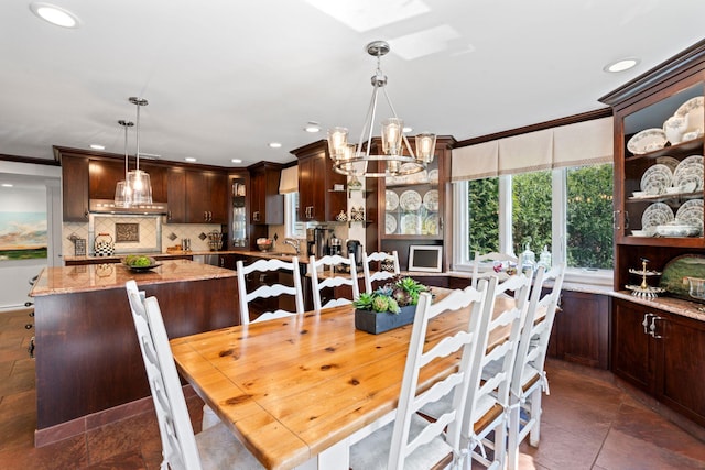 dining space featuring crown molding, recessed lighting, a skylight, and a chandelier